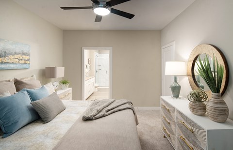 A bedroom with a bed, a dresser, and a ceiling fan.