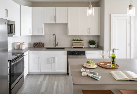 A modern kitchen with white cabinets and stainless steel appliances.