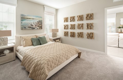 A bedroom with a large bed and a painting on the wall.