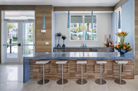 A kitchen with a bar area and a sink.