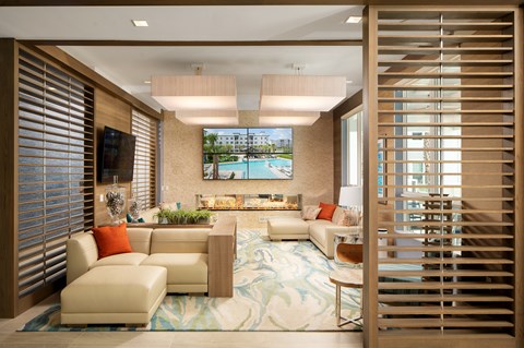 A living room with a large couch and a television on the wall.