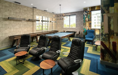 A room with a pool table and chairs.