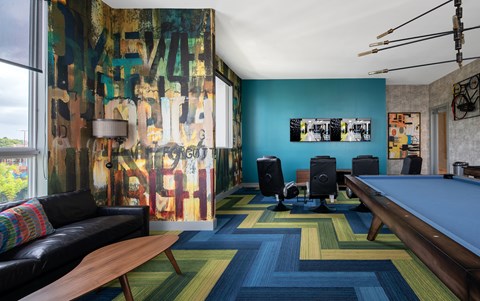 A room with a pool table and a couch.