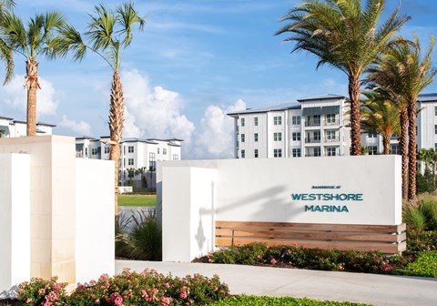 The Westshore Marina is a white building with a sign in front of it.