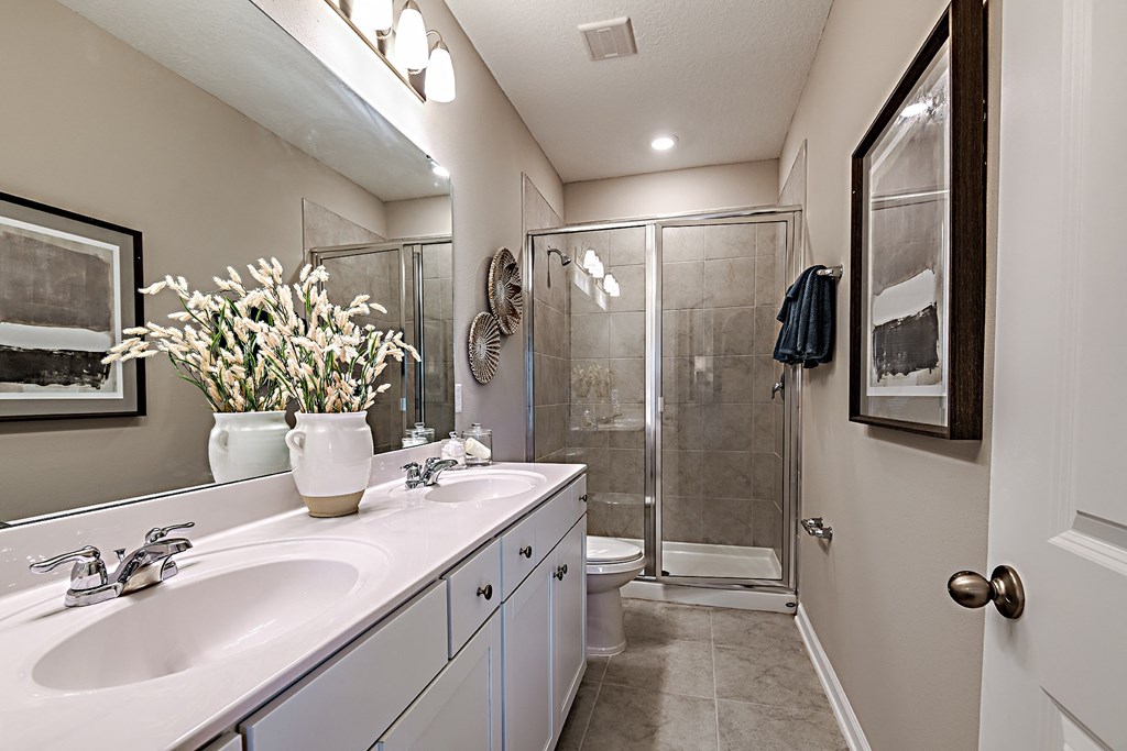A bathroom with a white sink and a glass shower.