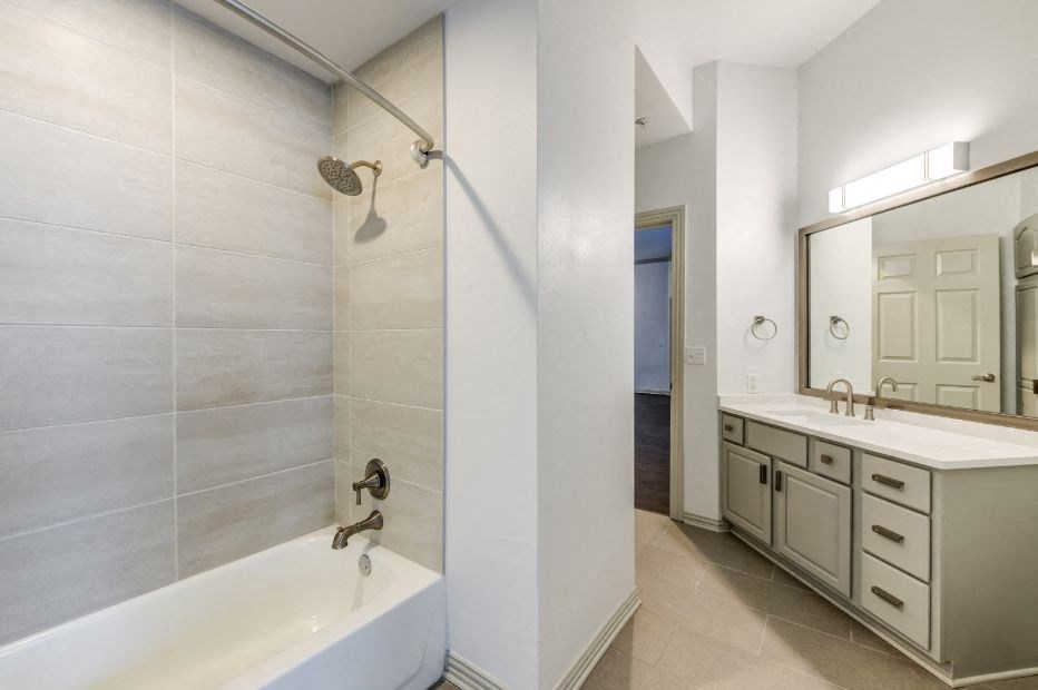 a bathroom with a tub and a sink and a mirror