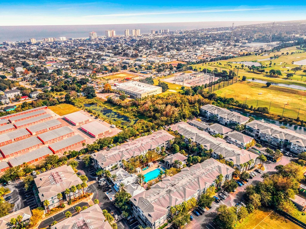 an aerial view of a neighborhood with houses and a city in the background