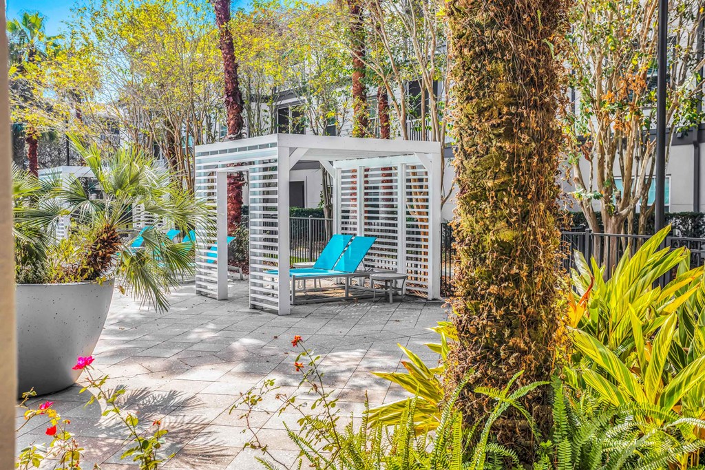 a patio with a blue chair and a white structure