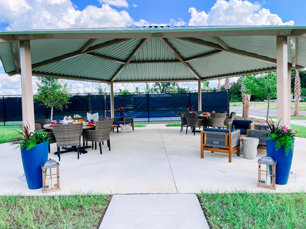 a covered patio with tables and chairs under a pavilion