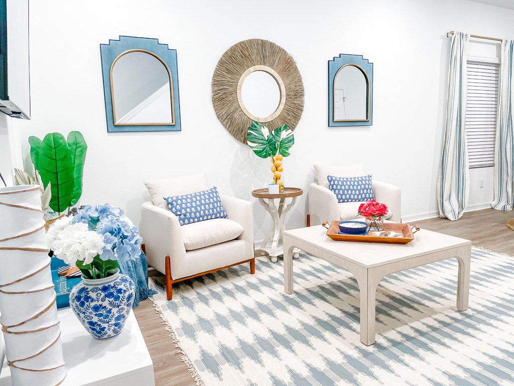 a living room with blue and white furniture and a mirror