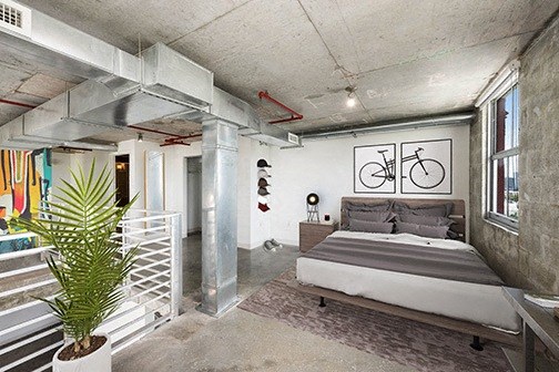 a bedroom with a bed and a bicycle on the wall