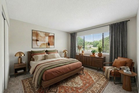 A bedroom with a large bed and a chair.