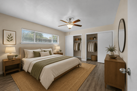 A bedroom with a large bed and a ceiling fan.