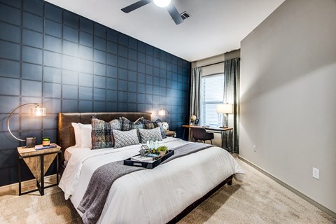 A bedroom with a bed, nightstand, and lamp.
