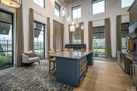 A kitchen with a large island and a dining table with chairs.