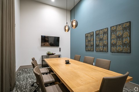A conference room with a long table and chairs.
