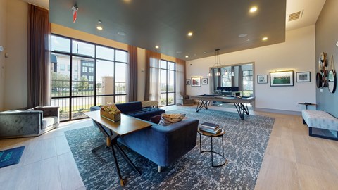 A living room with a blue couch and a large window.