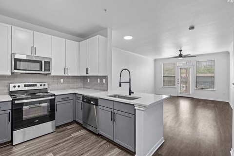 a kitchen with white cabinets and stainless steel appliances