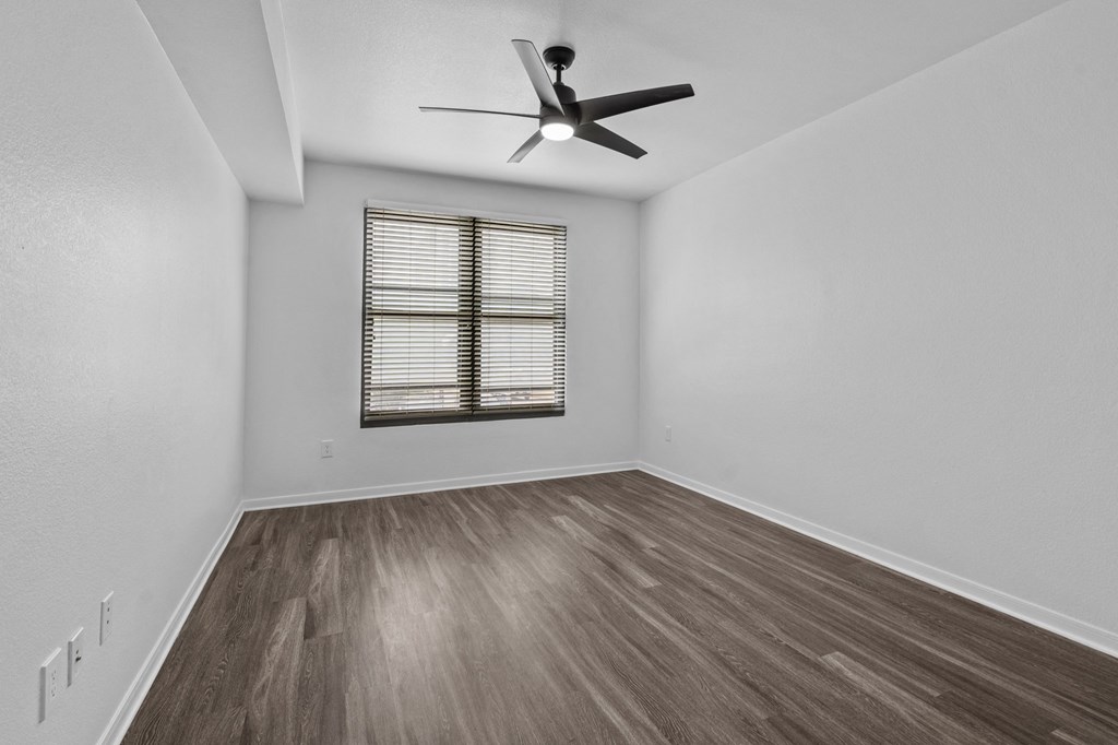 a bedroom with hardwood floors and a ceiling fan