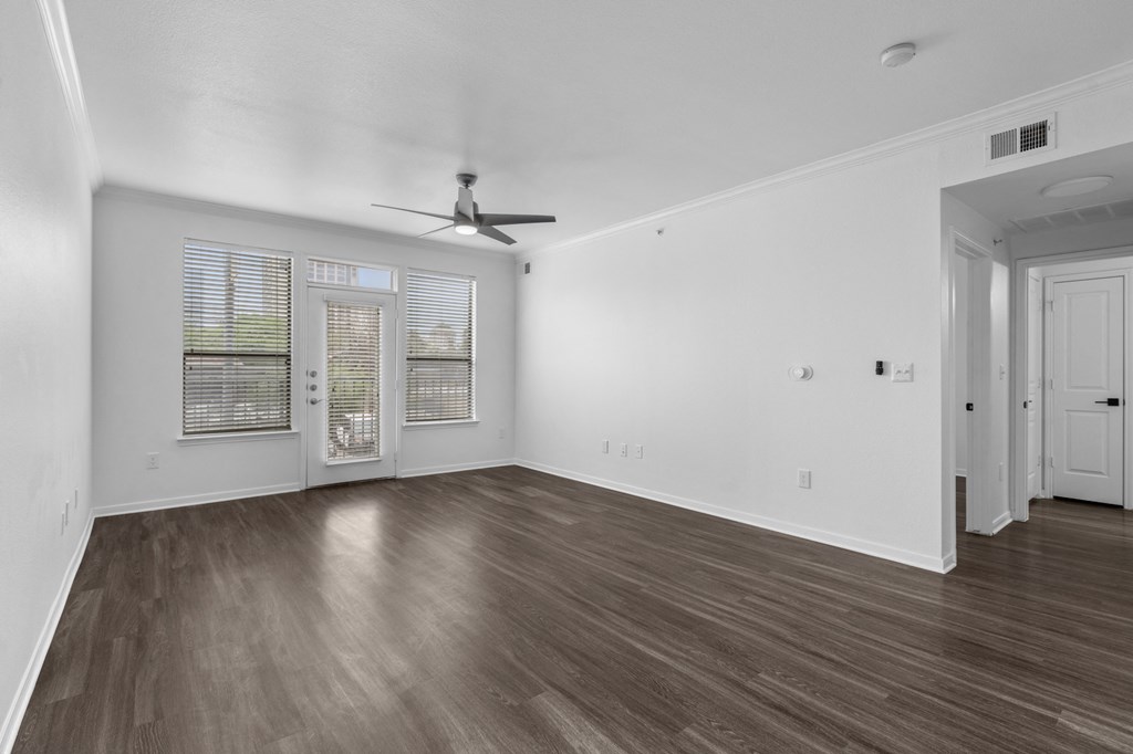a bedroom with hardwood floors and white walls
