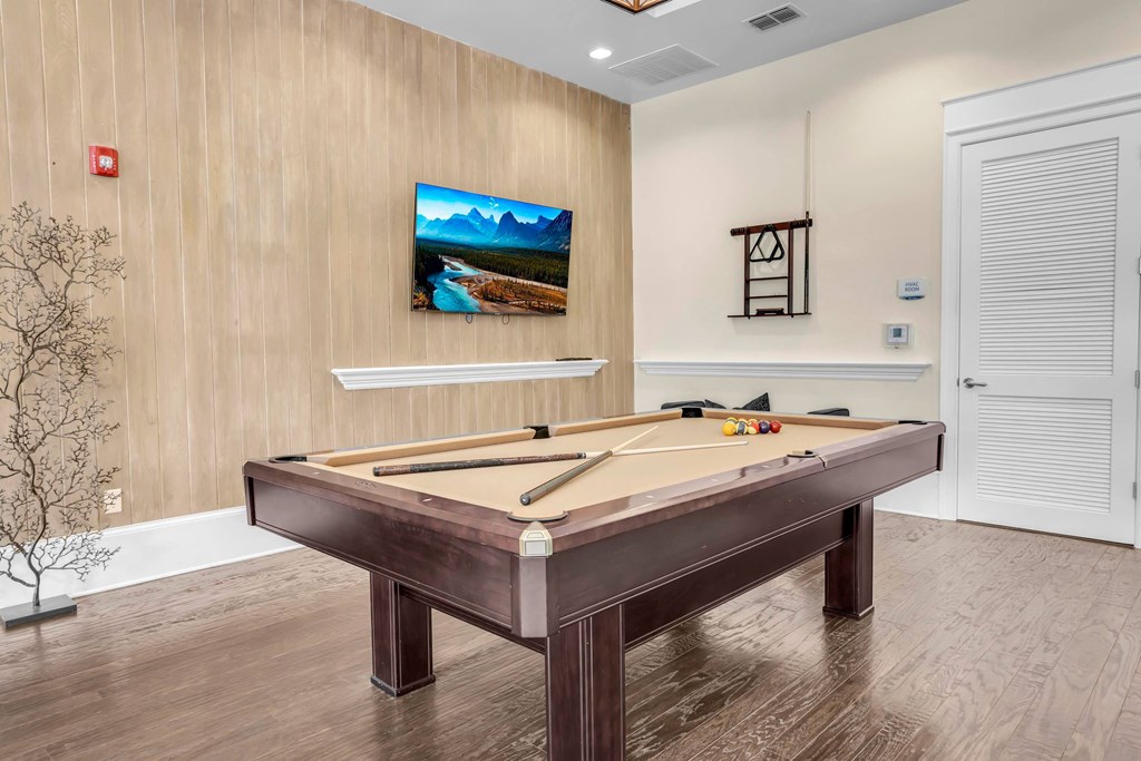 a games room with a pool table and a tv on the wall