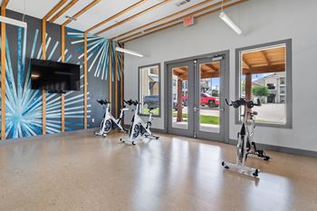 A room with exercise bikes and a television.