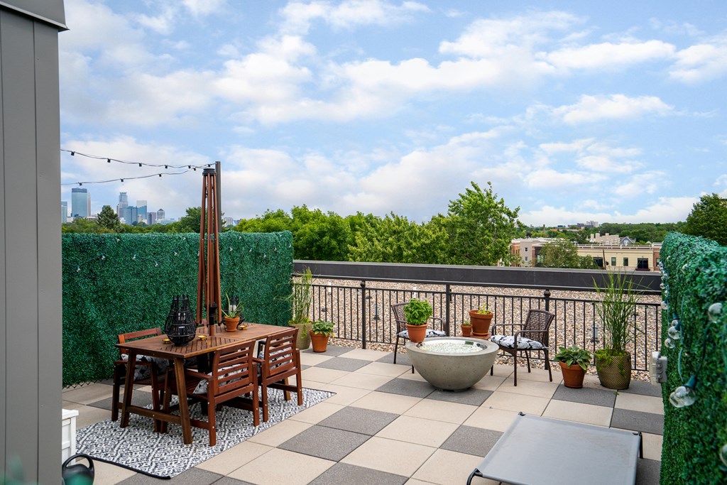 a roof terrace with a table and chairs and a view of the city