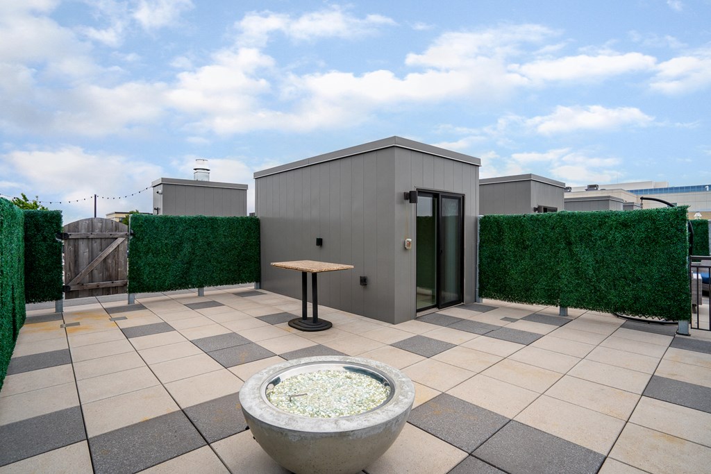 a roof terrace with a small building and a table