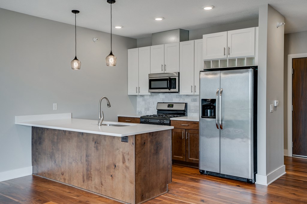 a modern kitchen with stainless steel appliances and a white counter top