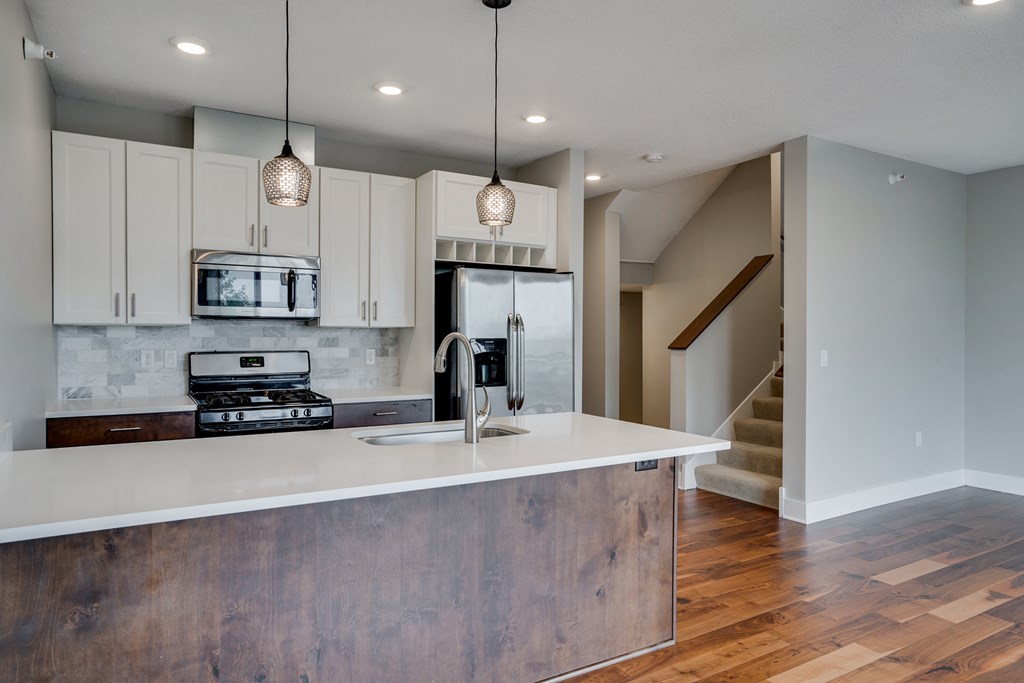 a kitchen with a white counter top and a sink