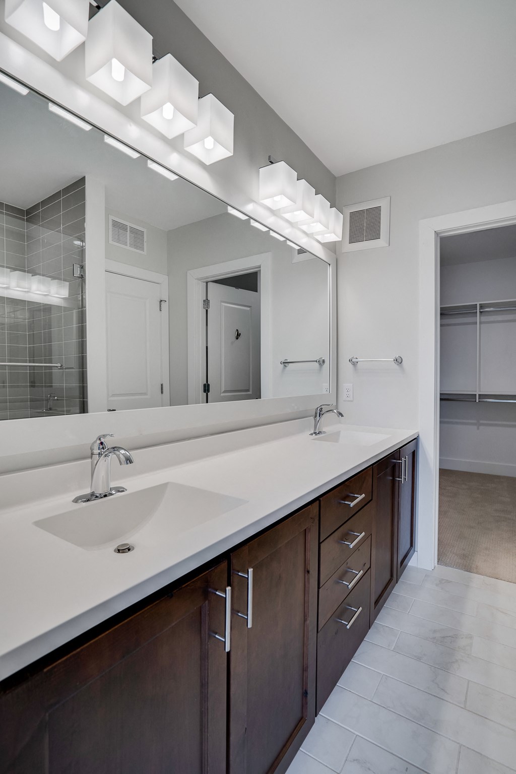 a bathroom with a long counter with a sink and a mirror