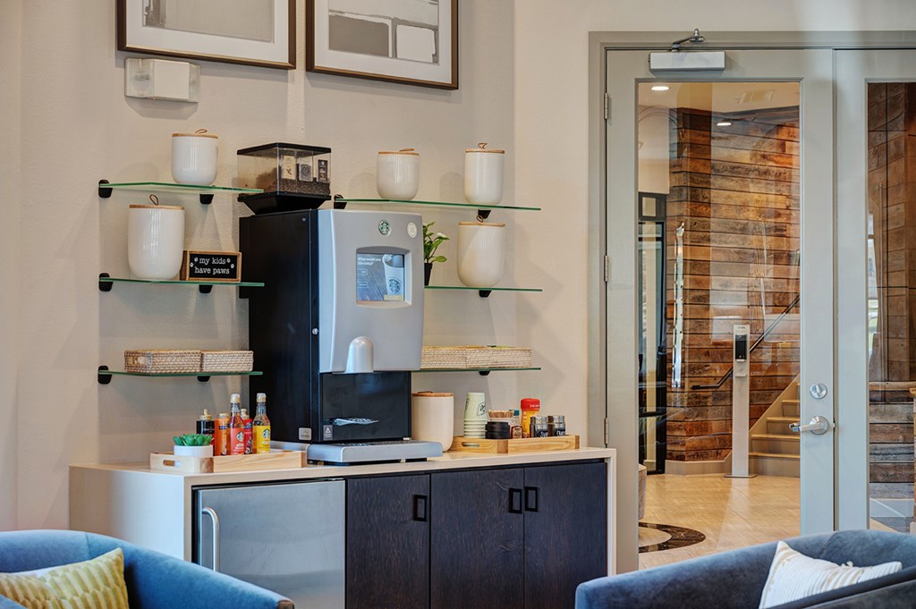 A modern kitchen with a black refrigerator and a glass door.