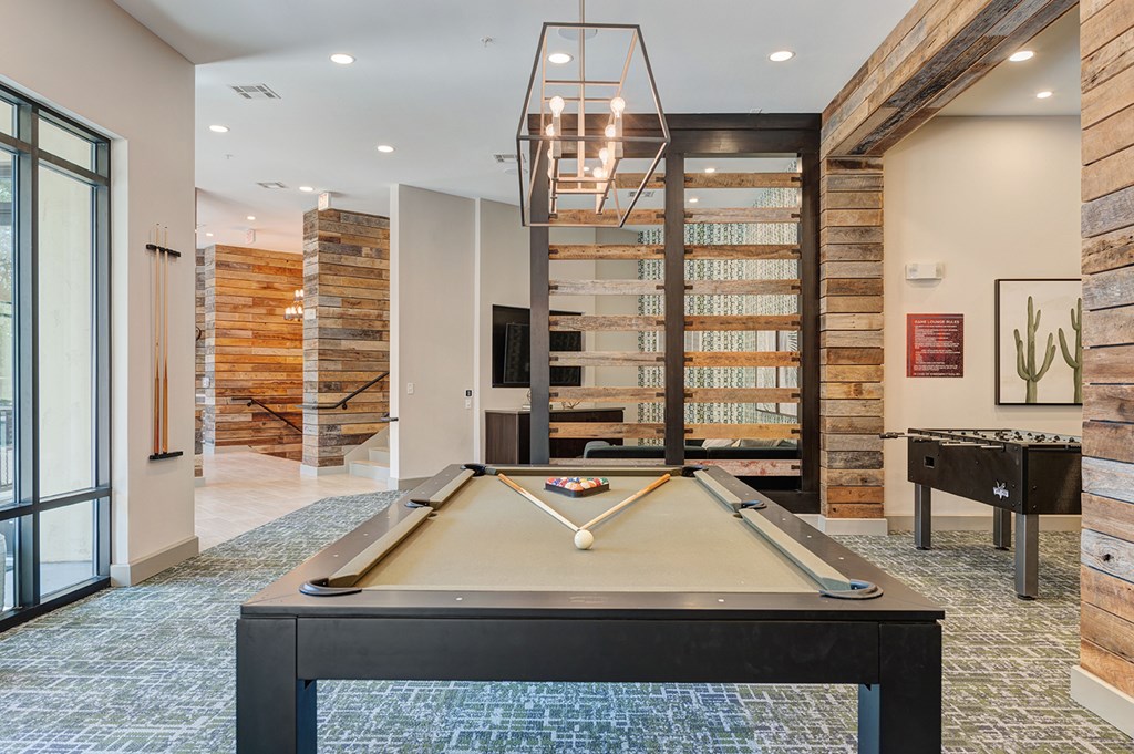 A pool table in a room with a wooden wall.