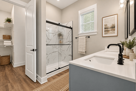 A bathroom with a white sink and a glass shower door.