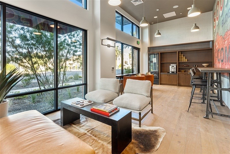 A modern living room with a large window and a view of trees outside.