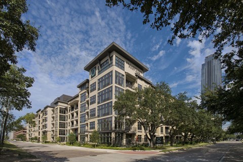 a large apartment building on a city street with trees