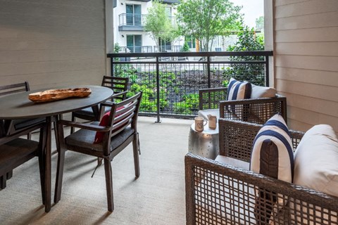 a living room with a table and chairs and a balcony