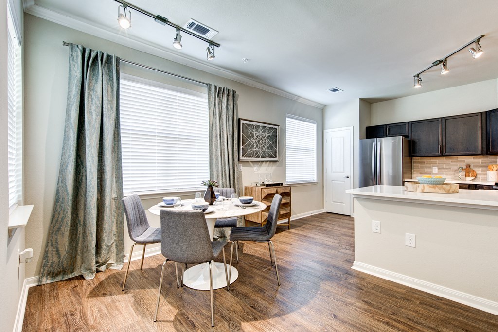 a dining room and kitchen with a table and chairs