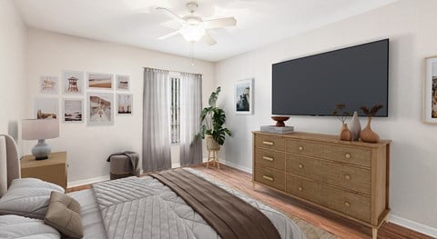 A bedroom with a bed, dresser, and a ceiling fan.