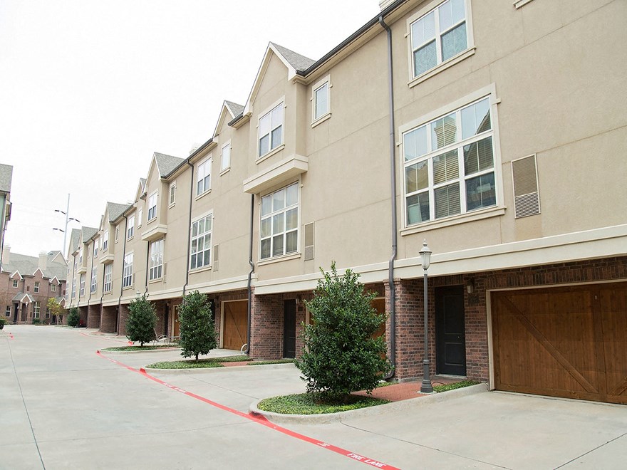 a row of townhomes with a sidewalk in front of them