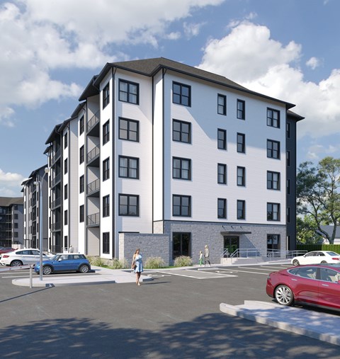A modern apartment building with a parking lot in front.
