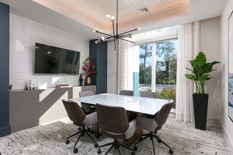 A conference room with a large table and chairs.