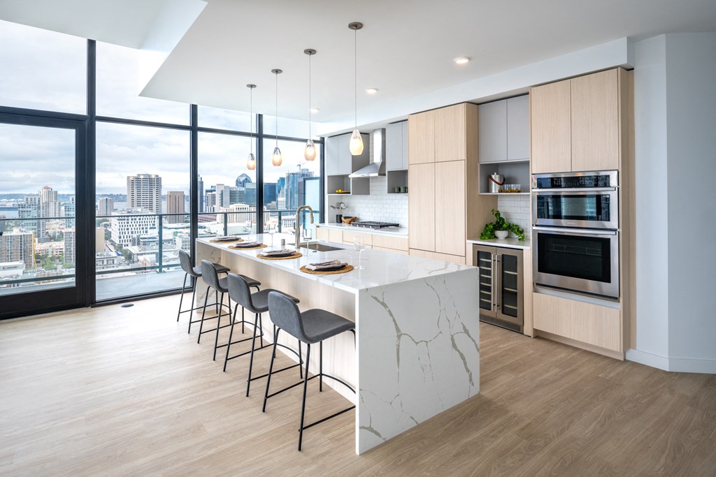 a kitchen with a marble counter top and a large window