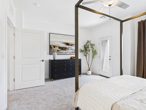 A bedroom with a four poster bed and a dresser.