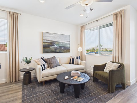 A living room with a white couch, a green armchair, and a coffee table.
