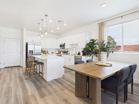 A modern kitchen with a dining table and chairs.