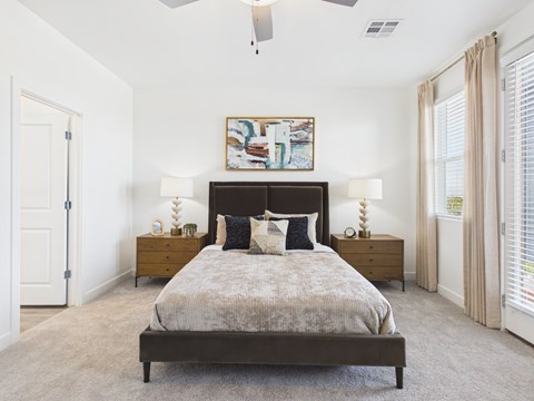 A bedroom with a large bed and a painting on the wall.