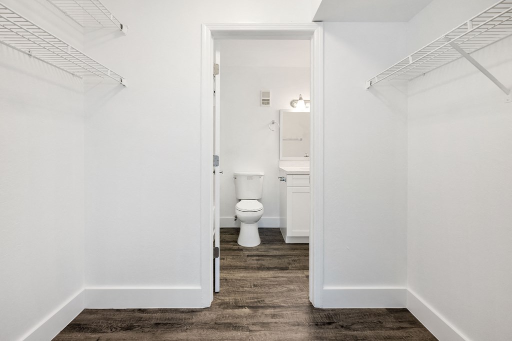a white bathroom with a toilet and a closet