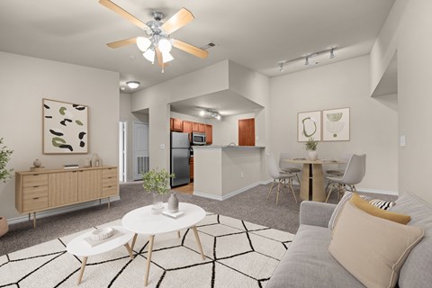 A modern living room with a grey couch, a white coffee table, and a ceiling fan.