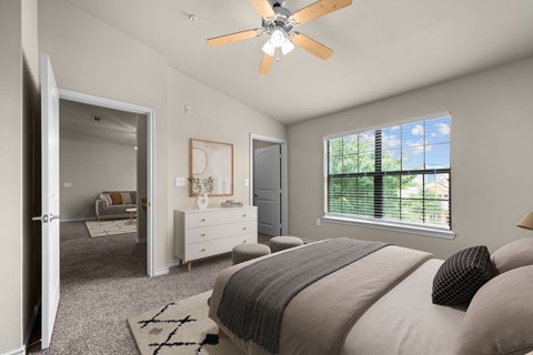 A bedroom with a large bed and a ceiling fan.